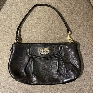 Coach strapped clutch. Black leather and red satin interior. 9 inches in length.